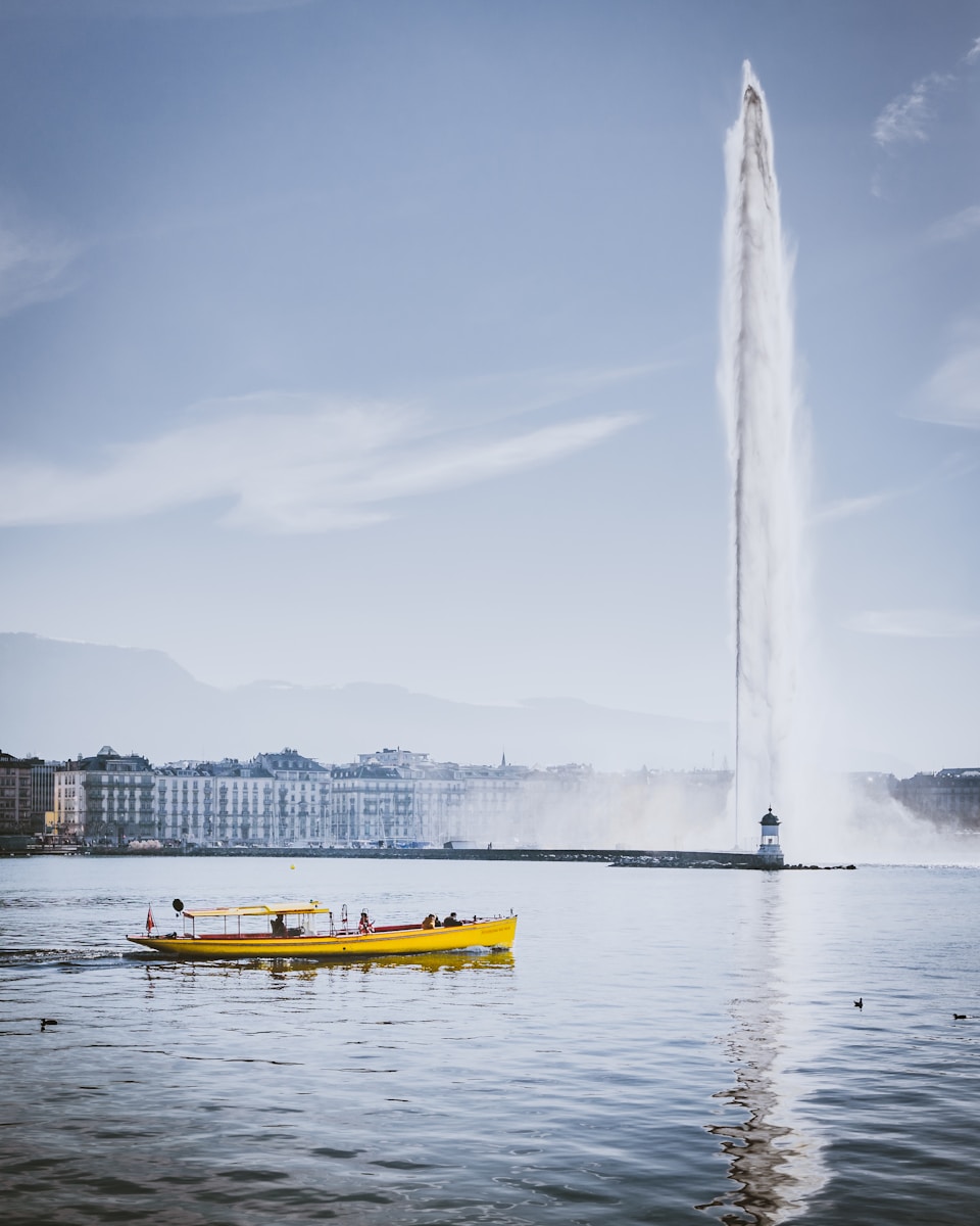 a boat in the water with a tall white monument in the background